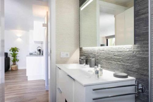 ein Badezimmer mit einem weißen Waschbecken und einem Spiegel in der Unterkunft Sunny Island Lago Martianez 5 in Puerto de la Cruz