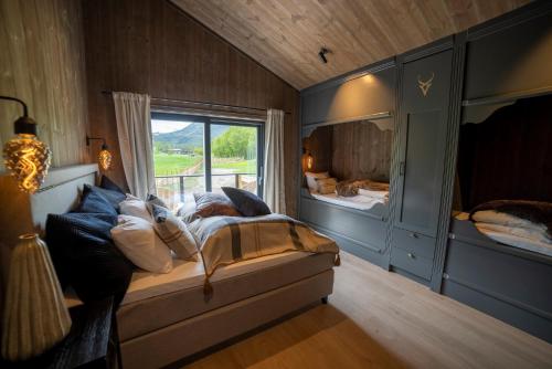 um quarto com uma cama e uma grande janela em Fjelleventyret gårdsovernatting em Skjåk