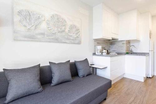 a living room with a couch and a kitchen at Sunnyland Lago Martianez 3 in Puerto de la Cruz