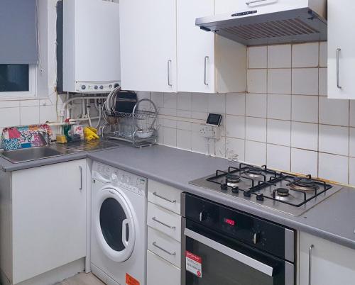 a kitchen with a stove and a washing machine at Grosvenor court in London