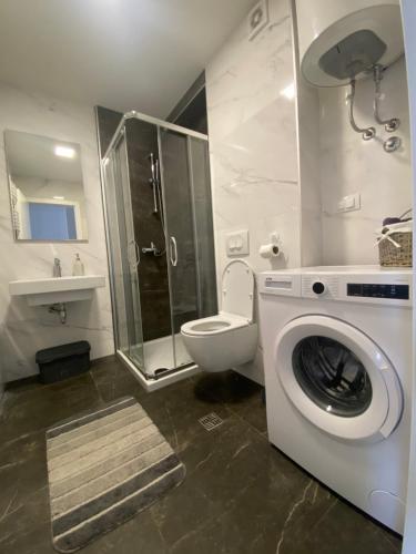 ein Badezimmer mit einer Waschmaschine und einem WC in der Unterkunft Infinity in Banja Luka