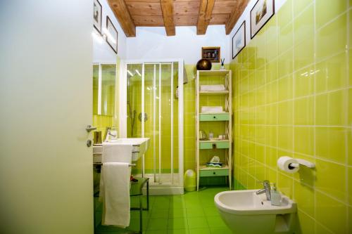 a green bathroom with a sink and a toilet at Mazzini Suite in Verona