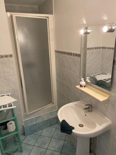 La salle de bains est pourvue d'un lavabo et d'un miroir. dans l'établissement Les Rolanges Chambres d'hôtes, à Saint-Bernard