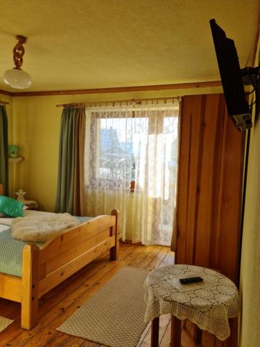 a bedroom with a bed and a window at Durda in Poronin
