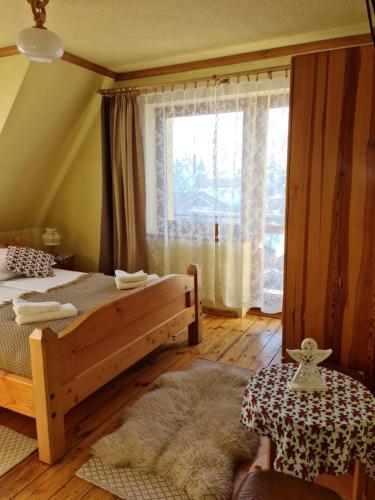a bedroom with a bed and a large window at Durda in Poronin
