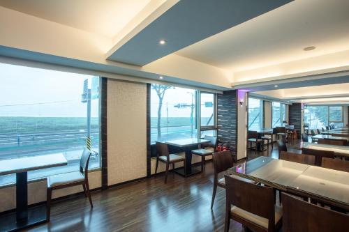 a restaurant with tables and chairs and a large window at 觀海樓海景大飯店 Hotel Cloud Riverside in Tamsui