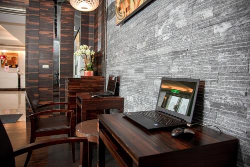 a laptop computer sitting on a wooden table in a restaurant at 觀海樓海景大飯店 Hotel Cloud Riverside in Tamsui