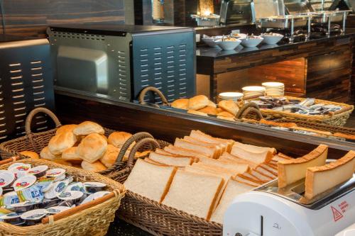 a table with baskets of bread and baskets of cheese at 觀海樓海景大飯店 Hotel Cloud Riverside in Tamsui