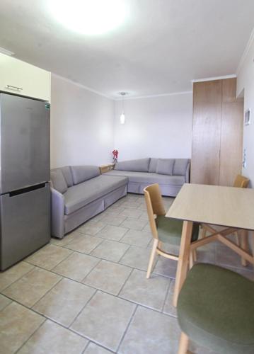 a living room with a couch and a table at Chios Xenia Studios & Apartments in Paralia Agias Foteinis