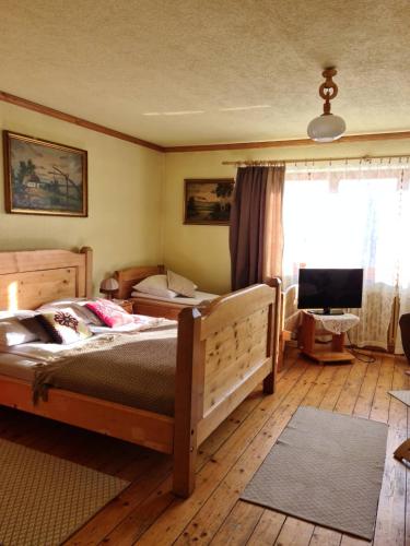 a bedroom with two beds and a flat screen tv at Durda in Poronin