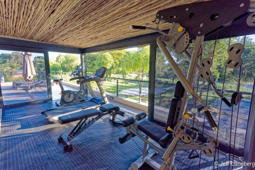 a gym with two exercise bikes in a room with windows at Elephant Point in Skukuza