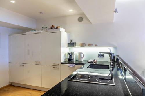 a kitchen with white cabinets and a stove at Haus Excelsior Top 38 in Seefeld in Tirol
