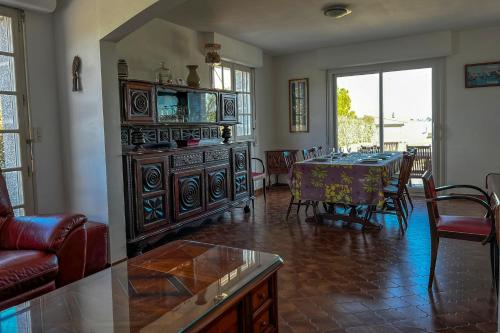 un salon avec une table et une salle à manger dans l'établissement L'Ostrea - Maison familliale accès mer, à Le Tour-du-Parc