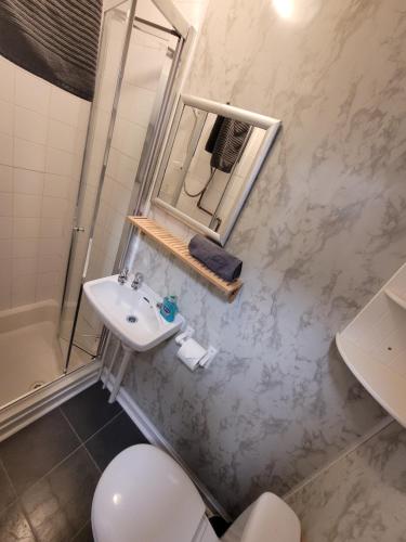 a bathroom with a sink and a toilet and a mirror at Palatine Court Holiday Flats - Blackpool Resort Collection in Blackpool