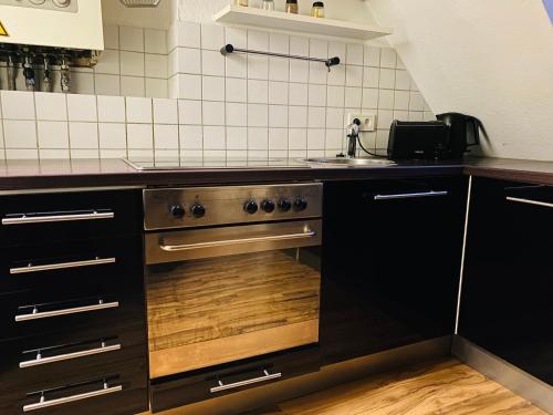a kitchen with a stove and a sink at Charmante Ferienwohnung mit Kaminofen in Bremerhaven