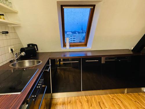 cocina con fregadero y ventana en Charmante Ferienwohnung mit Kaminofen, en Bremerhaven