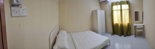 Un pat sau paturi într-o cameră la MESRA MUSAFIR HOMESTAY