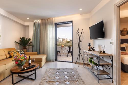 a living room with a couch and a tv at Lines Concept Accommodation in Rethymno Town