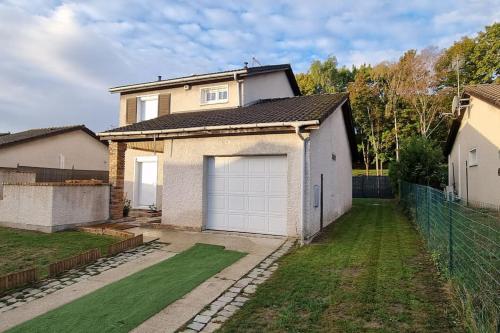a house with a garage in a yard at Maison Chaleureuse in Villepinte