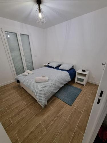 une chambre avec un lit et un parquet dans l'établissement Maison Chaleureuse, à Villepinte