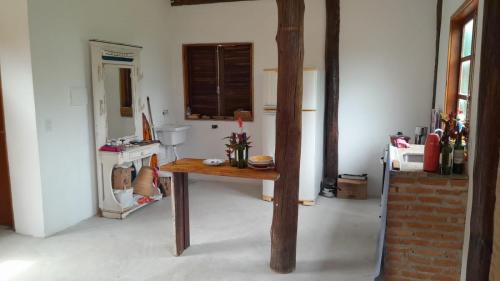 a kitchen with a wooden table in a room at Casa da JUJU - Praia da Lagoinha - Ubatuba in Ubatuba