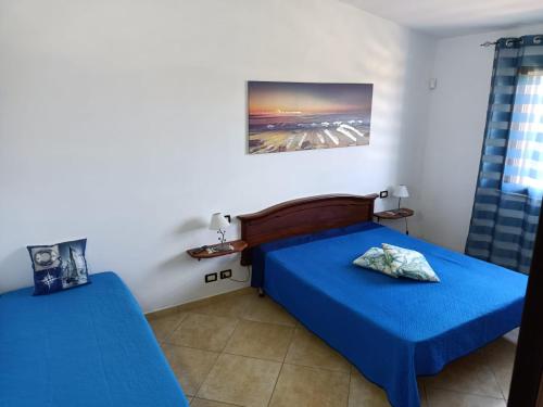 Dos camas en una habitación con sábanas azules. en Samir, en Custonaci