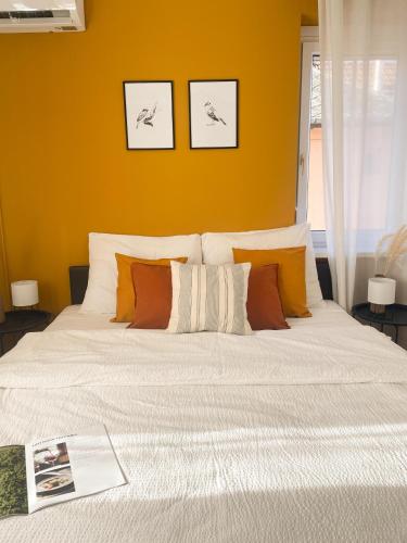 a bedroom with a large white bed with orange walls at Gólyafészek Vendégház in Egerszalók