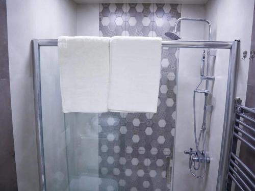 a bathroom with a shower with towels on a shower curtain at Explore Baku from YSB Apartment in Baku