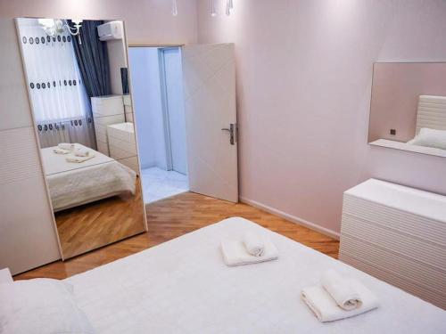 a room with a mirror and a bed with towels at Explore Baku from YSB Apartment in Baku