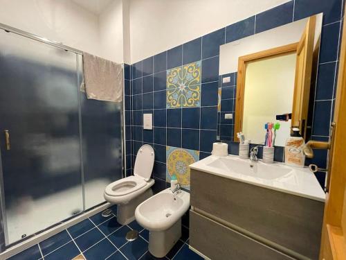 帕利努羅的住宿－Salerno Mare e Luci Village Palinuro，蓝色瓷砖浴室设有卫生间和水槽