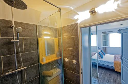 baño con ducha y puerta de cristal en L'Eden Blue à Saint Gilles les Bains, magnifique vue mer en Saint-Gilles-les-Bains