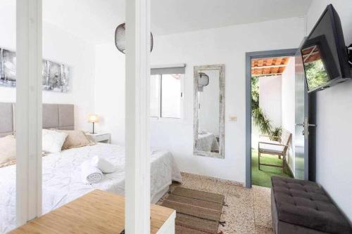 Sunny Island Casita San Andrés في San Andrés: غرفة نوم بيضاء فيها سرير وتلفزيون