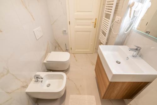 a white bathroom with a sink and a toilet at Petrin Tower Residence in Prague