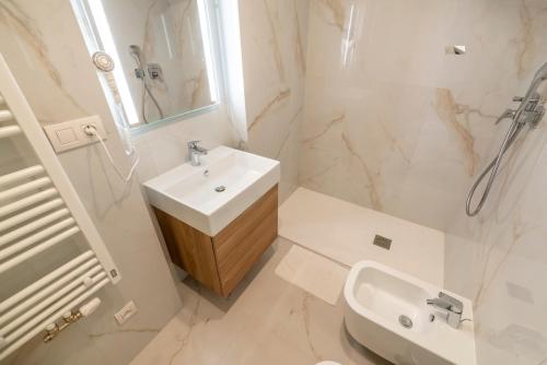 a white bathroom with a sink and a shower at Petrin Tower Residence in Prague