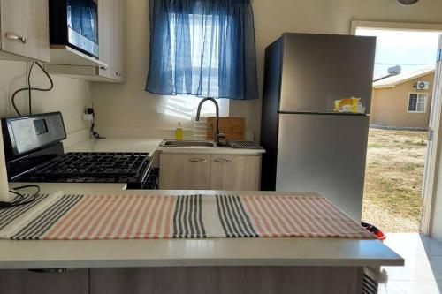 małą kuchnię z lodówką i kuchenką w obiekcie House of Bliss w mieście Portmore