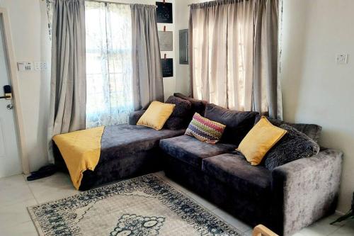 a living room with a couch and a window at House of Bliss in Portmore