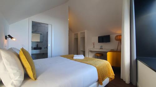 a bedroom with a white bed with yellow pillows at Seasons Porto-Gaia by MyStay in Vila Nova de Gaia