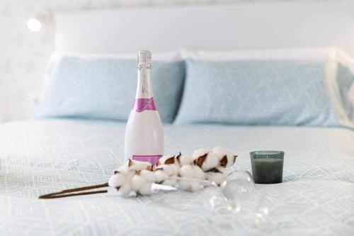 a bottle of wine and flowers on a bed at Sunnyland Villa Sueño Azul in Callao Salvaje
