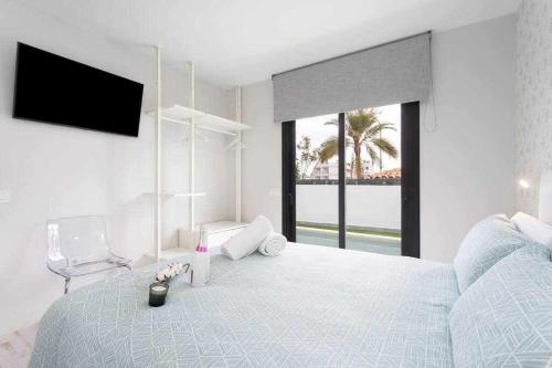 a white bedroom with a large bed and a television at Sunny Island Villa Sueño Azul in Callao Salvaje