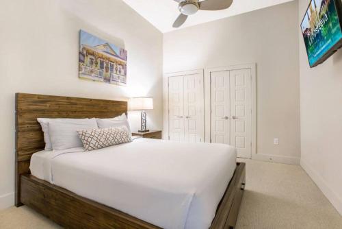 1 dormitorio con cama blanca y cabecero de madera en Cozy Condo 5-minute Walk to French Quarter en Nueva Orleans