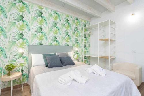 a bedroom with a white bed with a tropical wallpaper at Sunny Island Ático Adelfas San Andrés in San Andrés