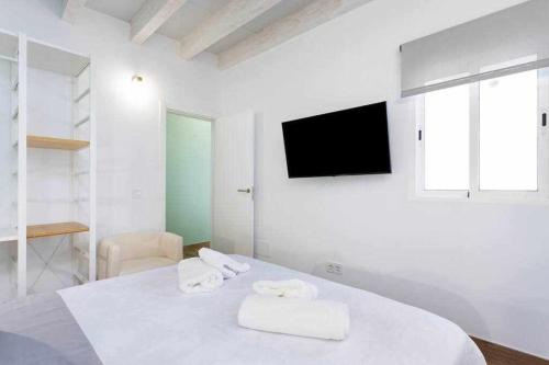 Un dormitorio blanco con una cama con toallas. en Sunny Island Ático Adelfas San Andrés en San Andrés
