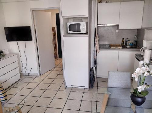 une petite cuisine avec un réfrigérateur et un micro-ondes dans l'établissement Résidence Graziella Studio 303, à Juan-les-Pins