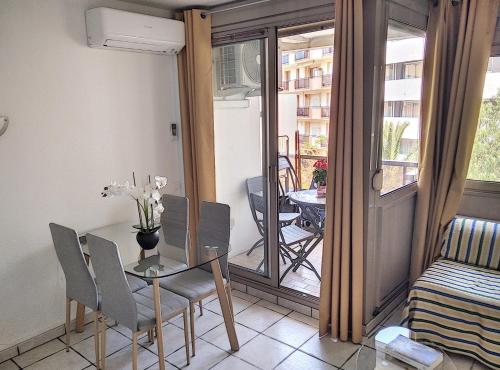 une salle à manger avec une table et des chaises et un balcon dans l'établissement Résidence Graziella Studio 303, à Juan-les-Pins