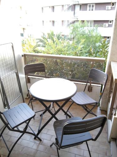 une table blanche et des chaises sur un balcon dans l'établissement Résidence Graziella Studio 303, à Juan-les-Pins