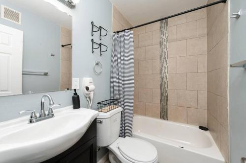 a bathroom with a sink and a toilet and a tub at Recently renovated 3BR home near Heritage Park! in Dundalk