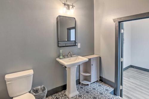 a bathroom with a sink and a toilet and a mirror at Cherokee Vacation Rental - On Main Street! in Cherokee
