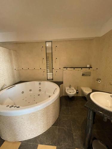 a bathroom with a tub and a toilet and a sink at Hotel SenS in Mierzyn