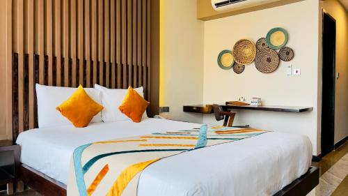 a bedroom with a large white bed with orange pillows at Kabira Country Club in Kampala