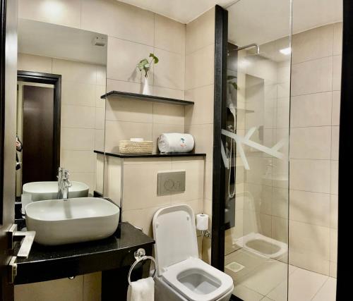a bathroom with a sink and a toilet and a shower at Kabira Country Club in Kampala